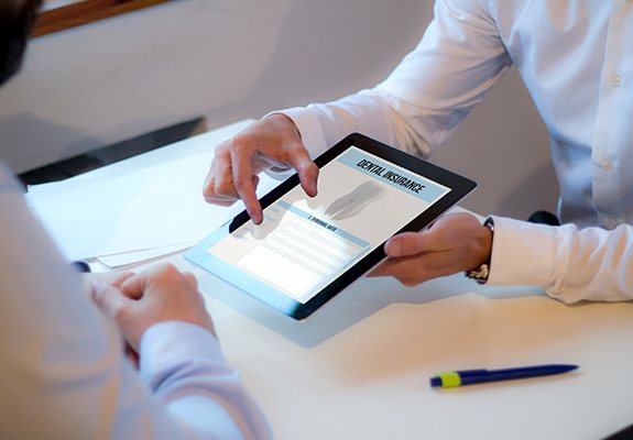 Two people looking at dental insurance forms on tablet computer