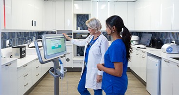 Oral surgeon and assistant looking at computer screen