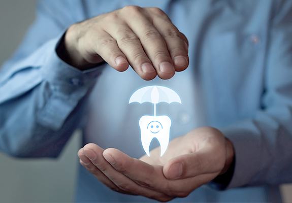 Hand holding a holographic icon of a tooth and an umbrella