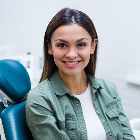 Smiling woman in dental chair after oral surgery procedure in North Bethesda