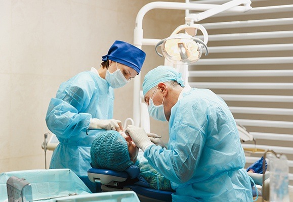 Oral surgeon and assistant performing oral surgery