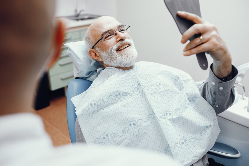 Man smiling in dental chair with dental implants